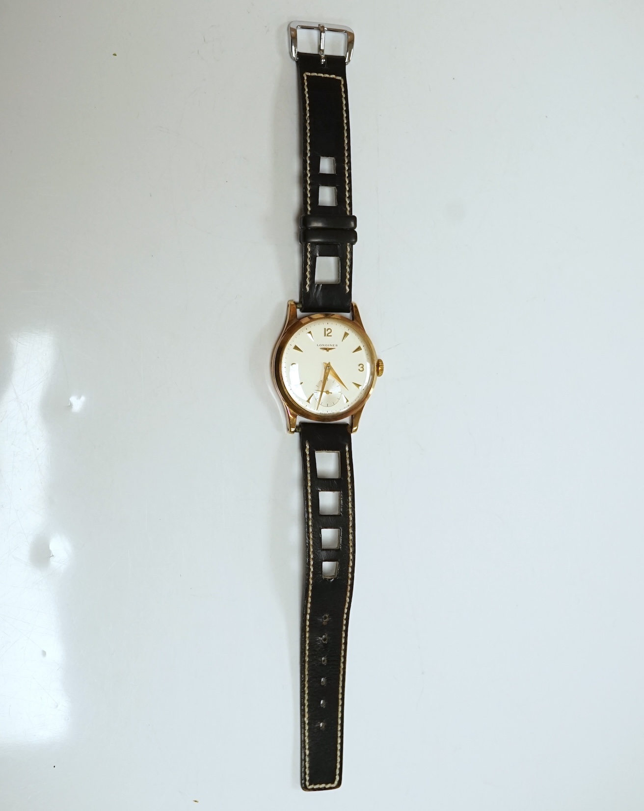 A gentleman's 9ct gold Longines manual wind wrist watch, with subsidiary seconds, case diameter 34mm, on a later associated leather strap, with Longines box. Condition - fair